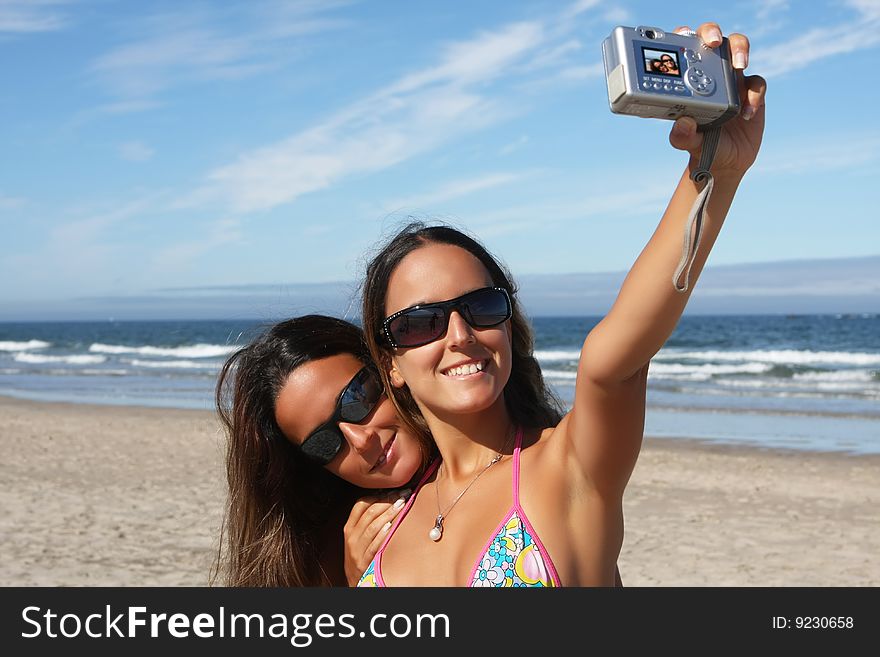 Twins taking a photo of themselves on the beach