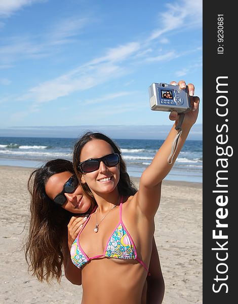 Twins taking a photo of themselves on the beach