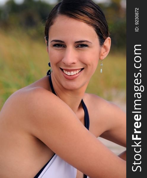 Young woman in white bathing suit sitting on beach. Young woman in white bathing suit sitting on beach