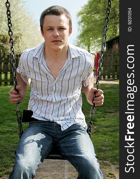 Young man siting on a swing