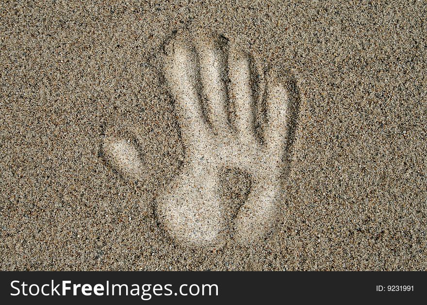White hand on the sand