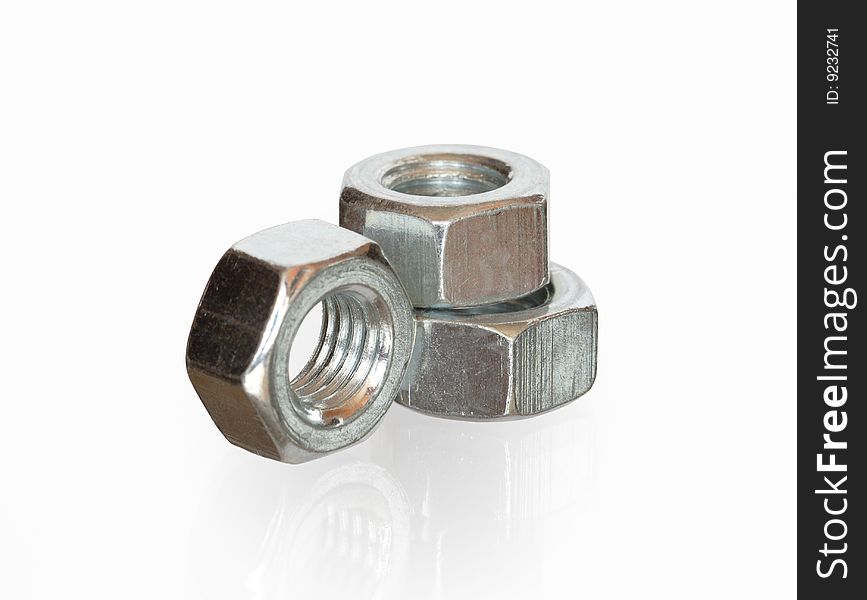 Close-up of three steel screw nuts isolated on white background with clipping path