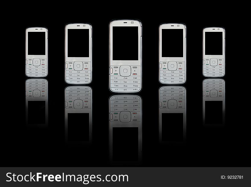 Five mobile (cellular) telephones in marching line with reflections on black background. Five mobile (cellular) telephones in marching line with reflections on black background.