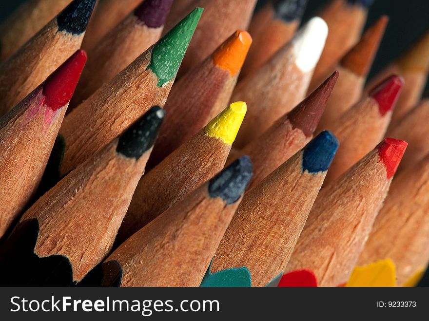 Old color pencils on black background