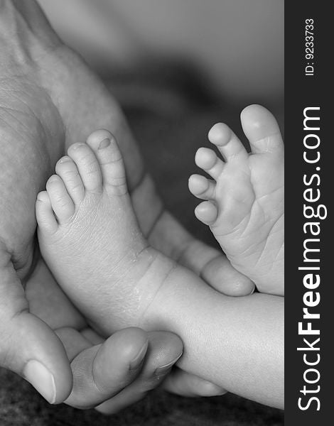 Feet of a newborn in her mothers hands