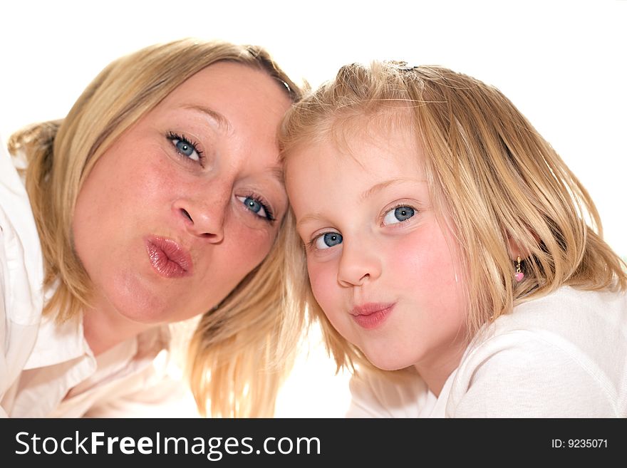 Mother and daughter giving kisses into camera