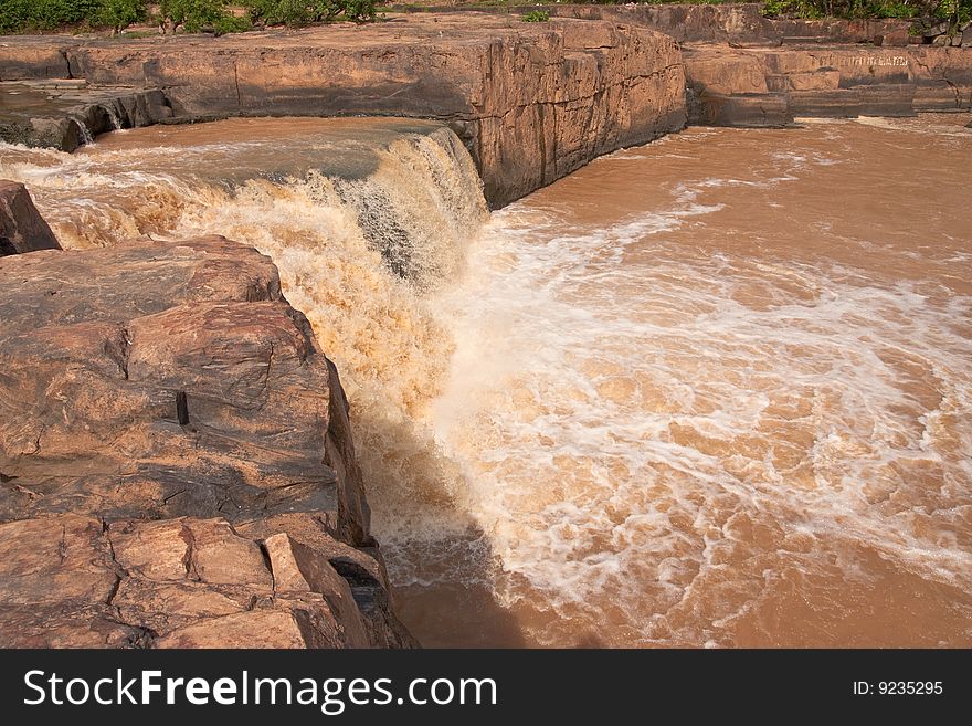 Turbid water of tropical waterfall after hard rain