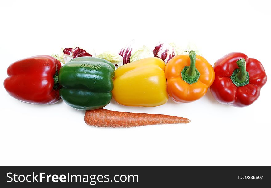 Line of colorful bell peppers surrounded by arugala, carrot. Line of colorful bell peppers surrounded by arugala, carrot