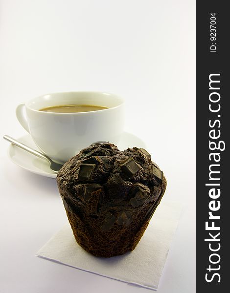 Cup of tea with single dark chocolate muffin on a white background. Cup of tea with single dark chocolate muffin on a white background