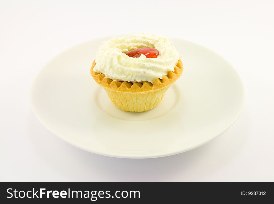 Single strawberry tart with cream on a white background