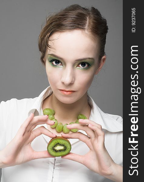 Portrait of young woman with pieces of kiwi. Portrait of young woman with pieces of kiwi