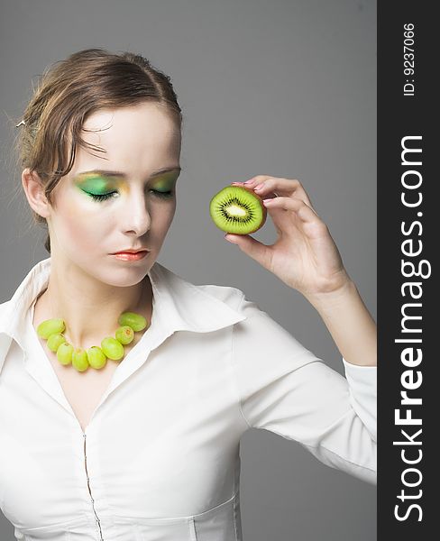 Portrait of young woman with pieces of kiwi