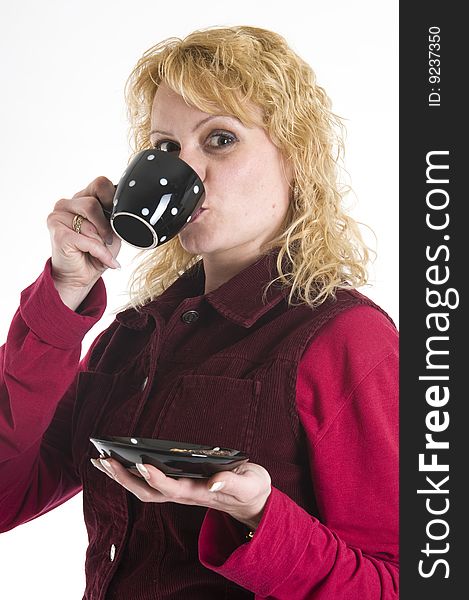 A beautiful woman is drinking coffee out of mugs in black. A beautiful woman is drinking coffee out of mugs in black