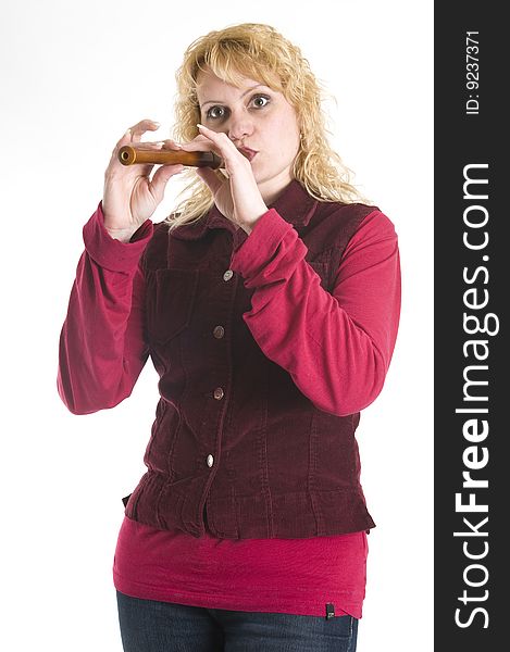 Young beautiful woman in a red shirt plays the flute. Young beautiful woman in a red shirt plays the flute