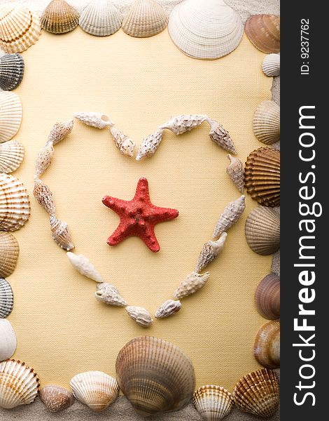 A beautiful yellow letter with shells on sand. A beautiful yellow letter with shells on sand