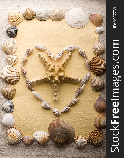 A beautiful yellow letter with shells on sand. A beautiful yellow letter with shells on sand