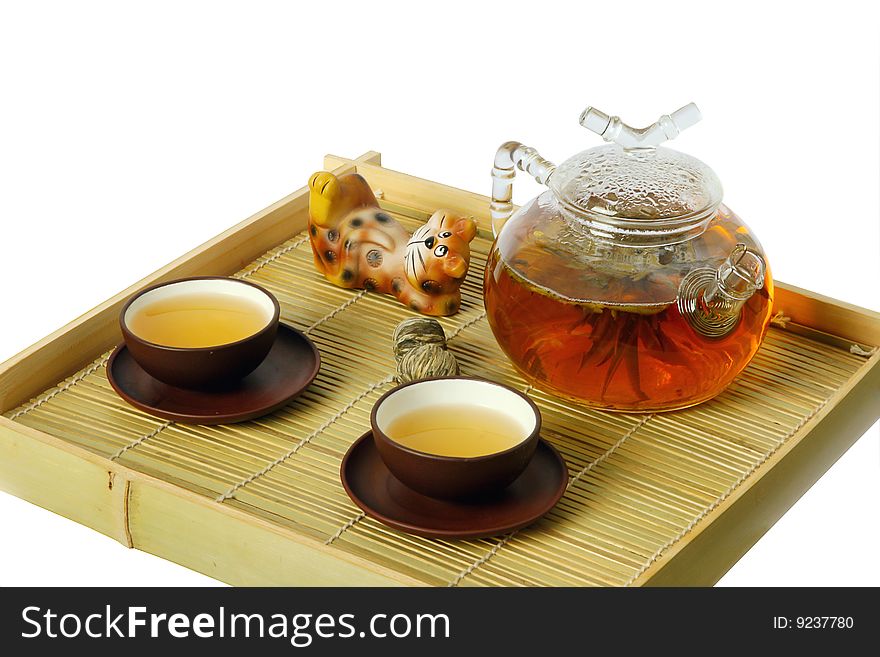 Tea serving in ceramic cups and glass teapot on wooden tray. Isolated on white. Tea serving in ceramic cups and glass teapot on wooden tray. Isolated on white.