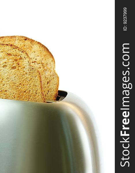 Toasted bread in a stainless steel toaster with a white background. Toasted bread in a stainless steel toaster with a white background.