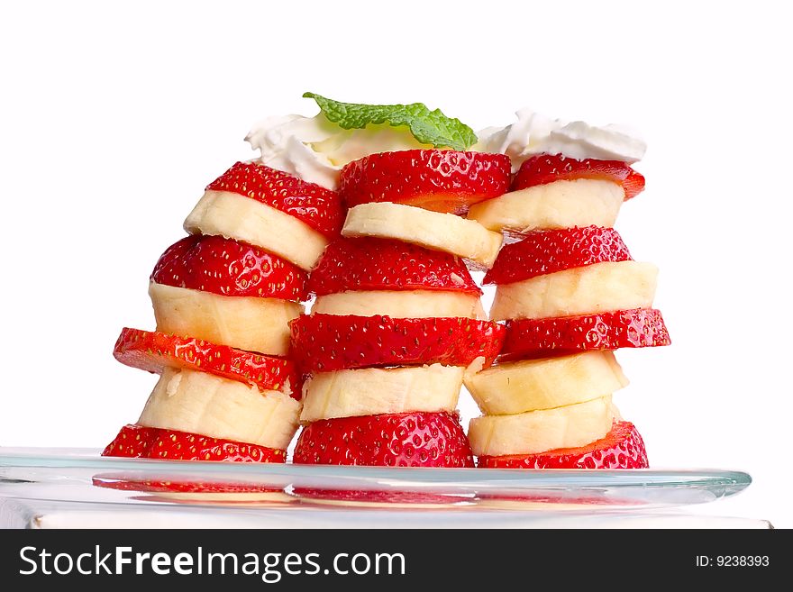 Slices of banana and strawberry, topped with whipping cream. Isolated on white. Slices of banana and strawberry, topped with whipping cream. Isolated on white