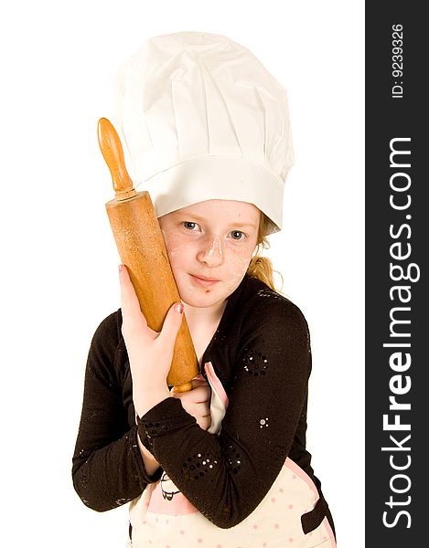 Young cook wearing a chefs hat is holding a woorden rolling pin isolated on white. Young cook wearing a chefs hat is holding a woorden rolling pin isolated on white