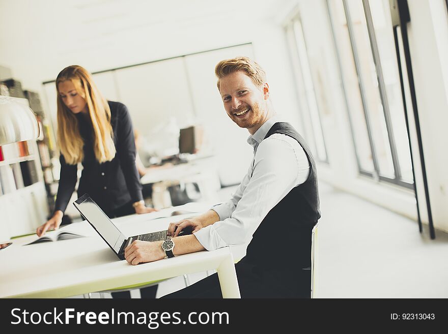 Woman With Male Colleague Working In Office