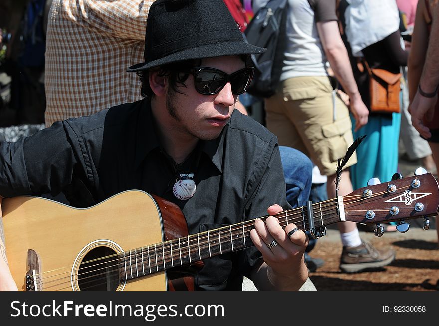Street Performer With Sunglasses On Guitar