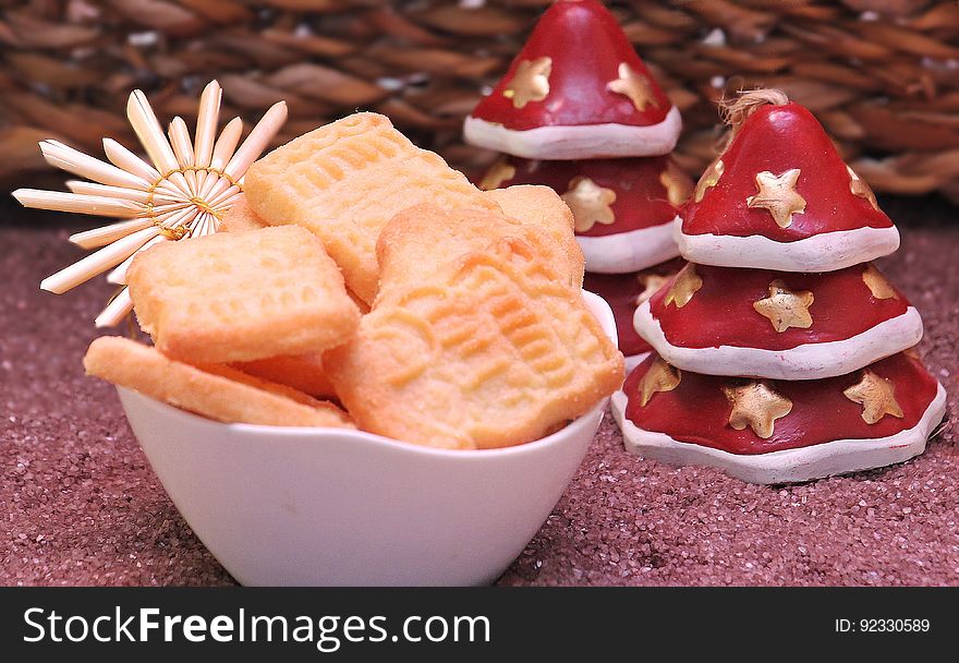A bowl of cookies with Christmas decorations on a table. A bowl of cookies with Christmas decorations on a table.