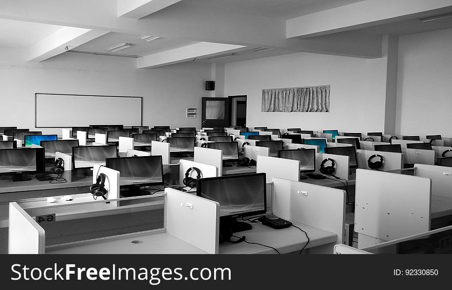 An classroom with cubicles with computers and headsets. An classroom with cubicles with computers and headsets.