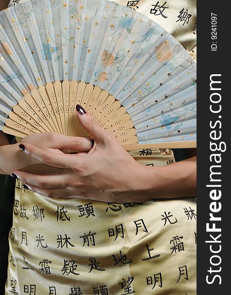 A picture of chinese traditional cheongsam and traditional fan. A picture of chinese traditional cheongsam and traditional fan.