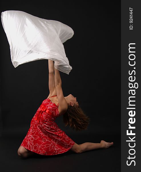 Elegant young flexible woman in red-white outfit with a big scarf