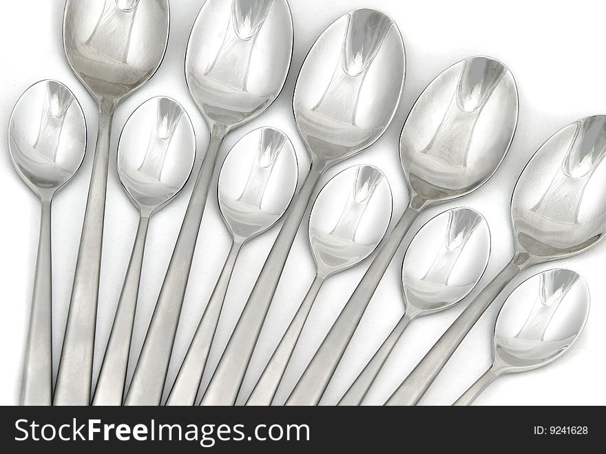 Metallic spoons on white background