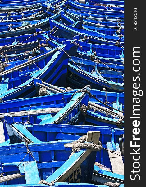 Close-up of many blue fishing boats in bright sunlight. Close-up of many blue fishing boats in bright sunlight