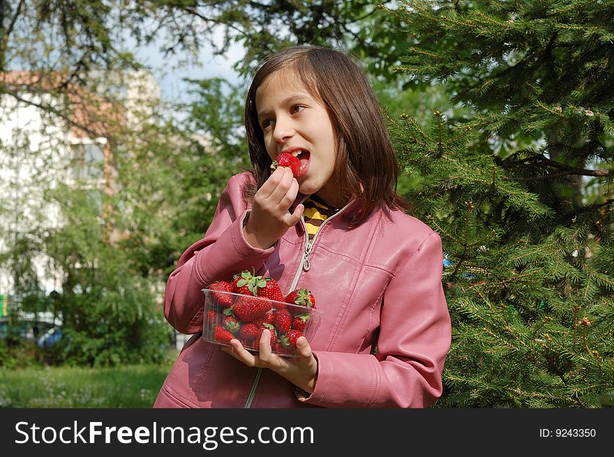 Happy young girl holding strawberries. Happy young girl holding strawberries.