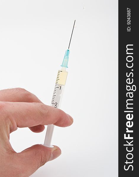 Medical syringe in a hand on a white background