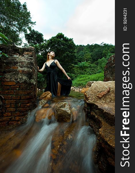 Young woman relaxing outdoor at the tropical waterfall. Young woman relaxing outdoor at the tropical waterfall