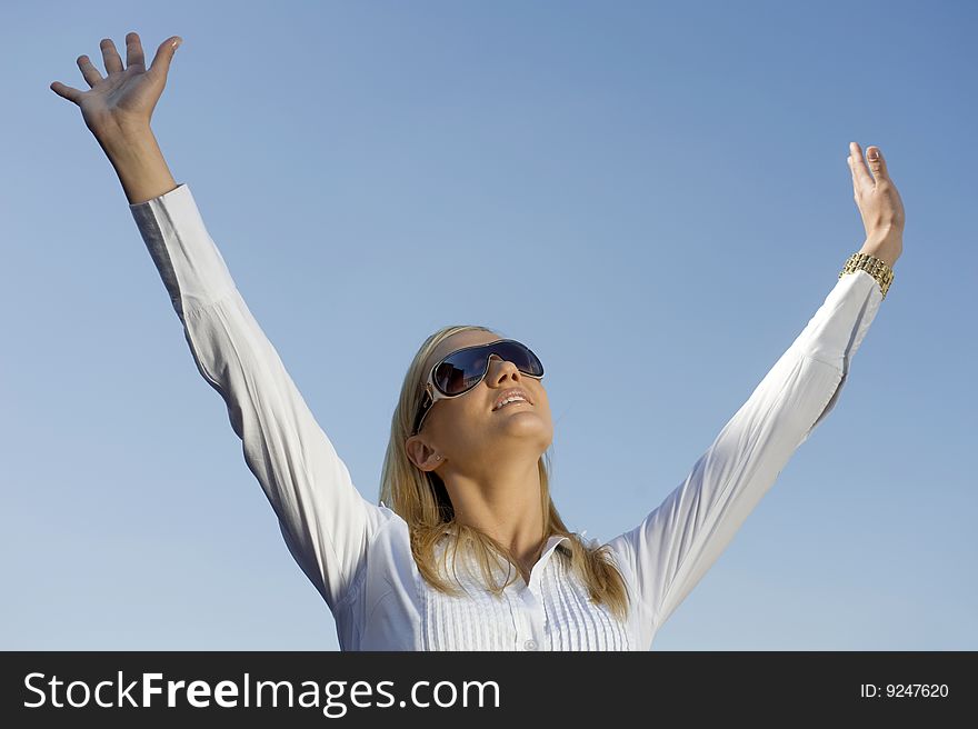 Woman with lifted hands on the background of the sky. Woman with lifted hands on the background of the sky