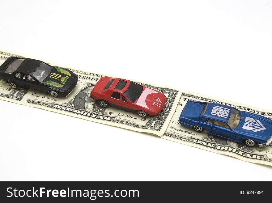 Toy cars over a road made of bills. Toy cars over a road made of bills