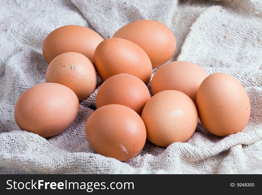 Ten chicken eggs laying on a sacking. Ten chicken eggs laying on a sacking