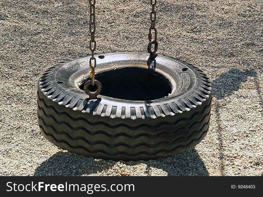 A picture of a tire swing with no children swinging