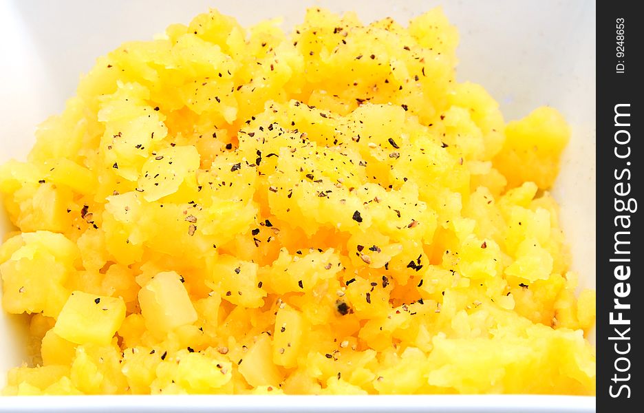 Cooked and mashed swede with black pepper in a dish