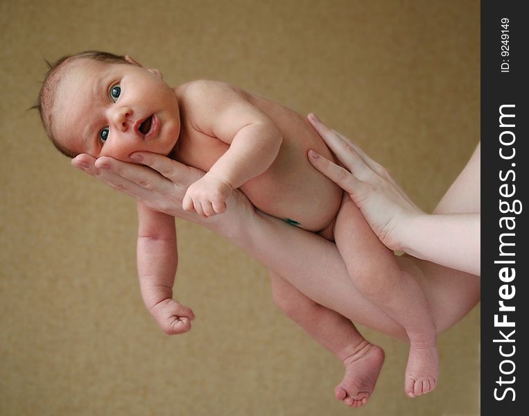 The child on hands of mother against a wall