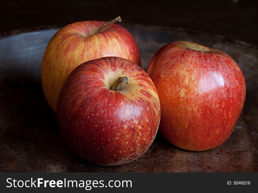 Three fresh red apples on dark wooden background. Three fresh red apples on dark wooden background