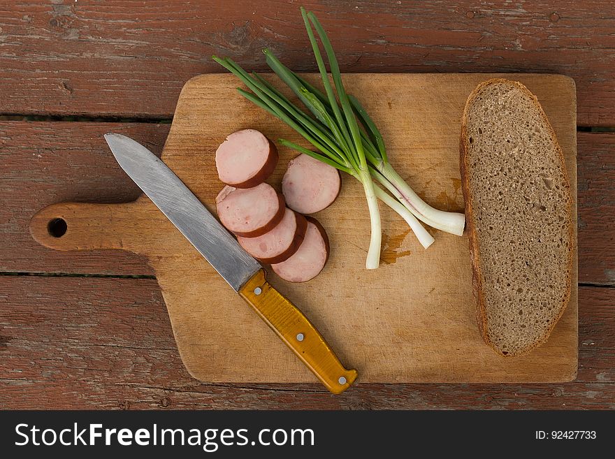 Kitchen Knife Next to Slice Bread on Chopping Board