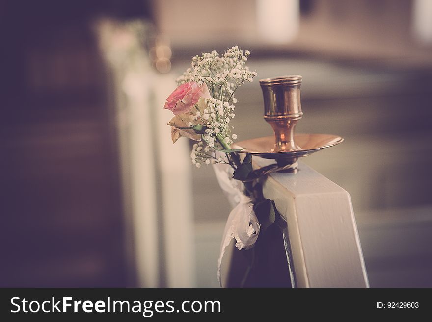 A copper candelabrum with a bouquet of flowers.