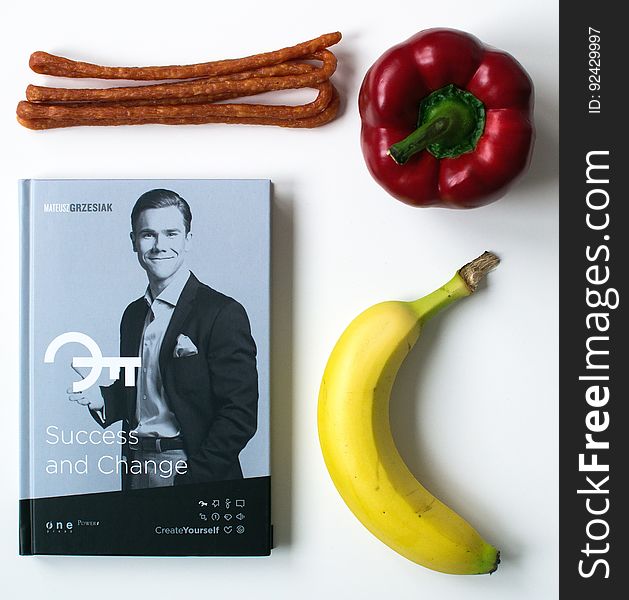 Book entitled "Success and Change" by Mateusz Grzesiak surrounded on three sides by different foods isolated on a white background. Book entitled "Success and Change" by Mateusz Grzesiak surrounded on three sides by different foods isolated on a white background.