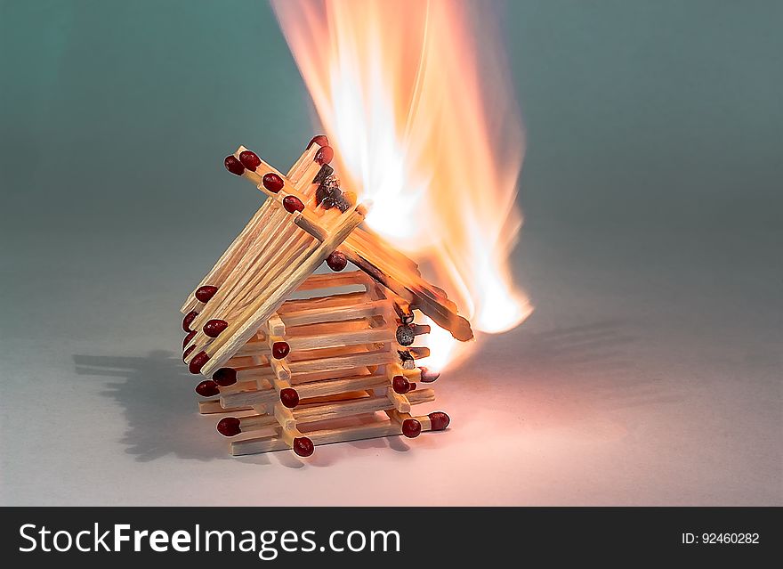A house made of matchsticks burning in fire. A house made of matchsticks burning in fire.