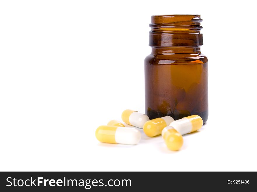 Glass bottle with yelllow capsules on white background