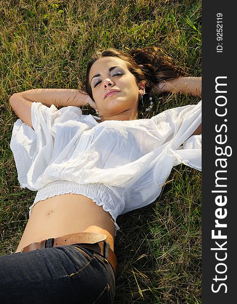 Portrait of young female beauty lying on the grass. Portrait of young female beauty lying on the grass