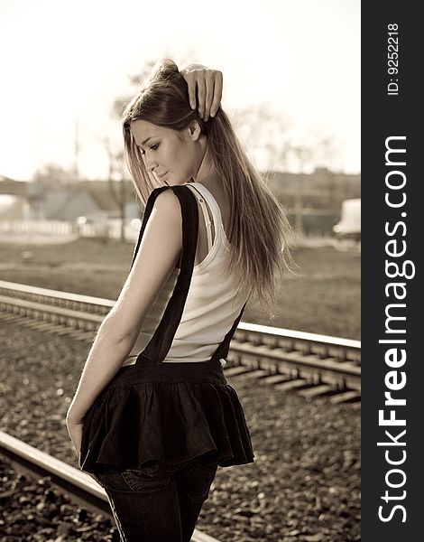 Young beautiful brunette girl standing on the rails