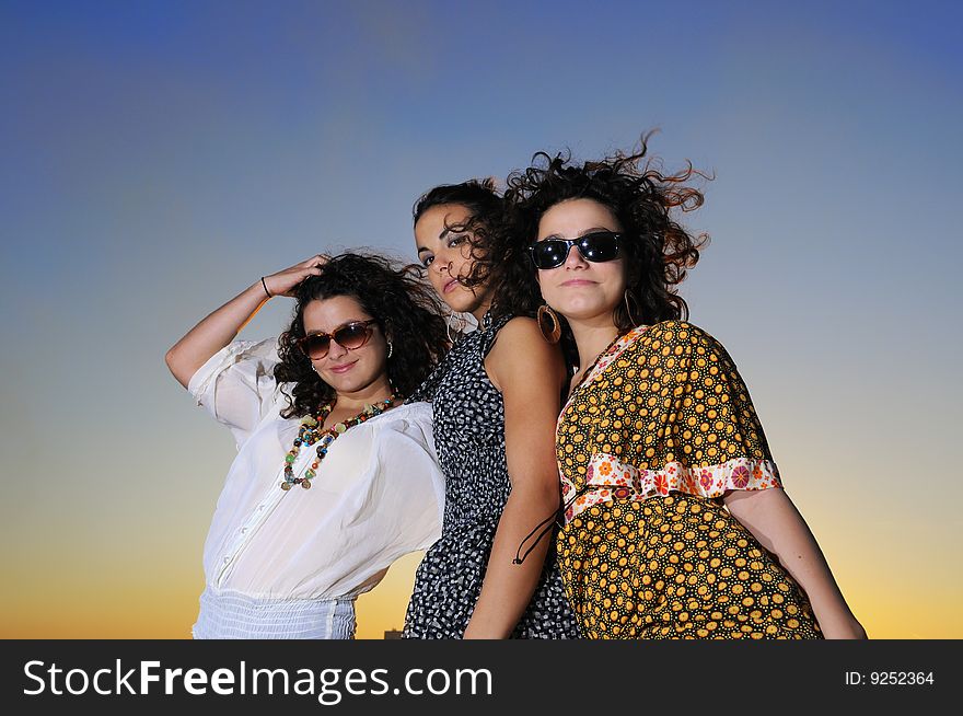 Portrait of three trendy girls posing at sunset. Portrait of three trendy girls posing at sunset